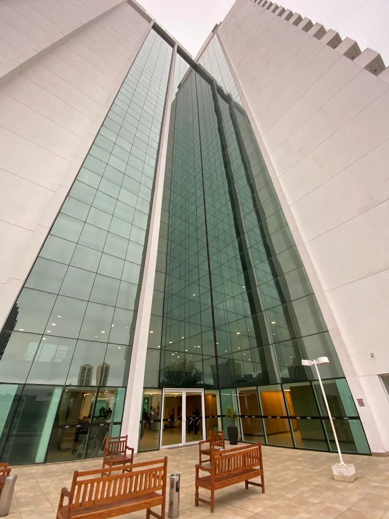 Entrada envidraçada da sede do Grupo Orion, com área de convivência